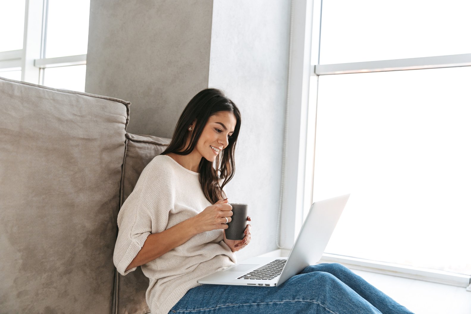 Smiling Young Woman Using Laptop Computer